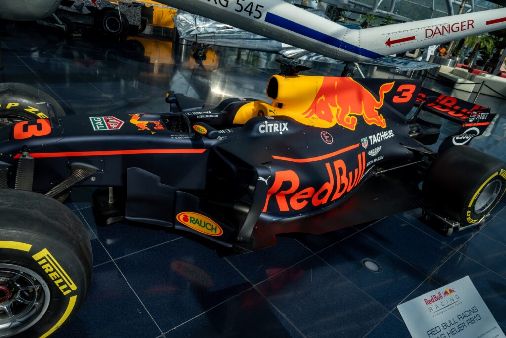 Eine Red Bull-Dose mit Motorsport- und Extremsport-Elementen, symbolisiert Erfolg und globale Expansion 2024.