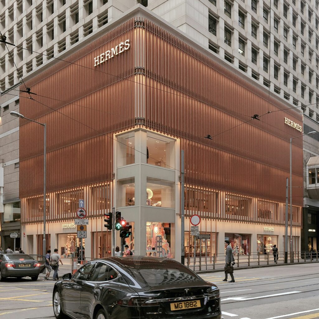 Hermès Finanzergebnisse 2024: Hermès-Logo auf luxuriösem Lederhintergrund mit steigenden Finanzdiagrammen für 2024.