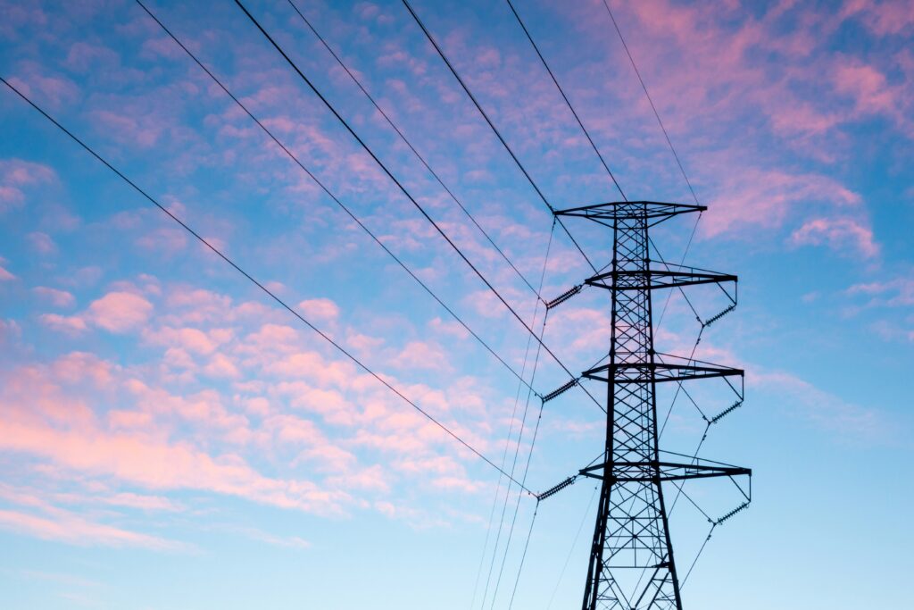 EU Energiesicherheit erneuerbare Energien: Hochspannungsleitungen vor Windrädern und Solarpanelen.