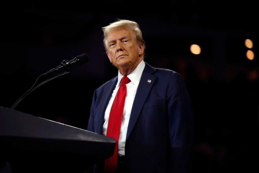 Trump Ukraine Spannungen eskalieren: Donald Trump bei einer Rede, im Hintergrund die Flaggen der USA und der Ukraine.