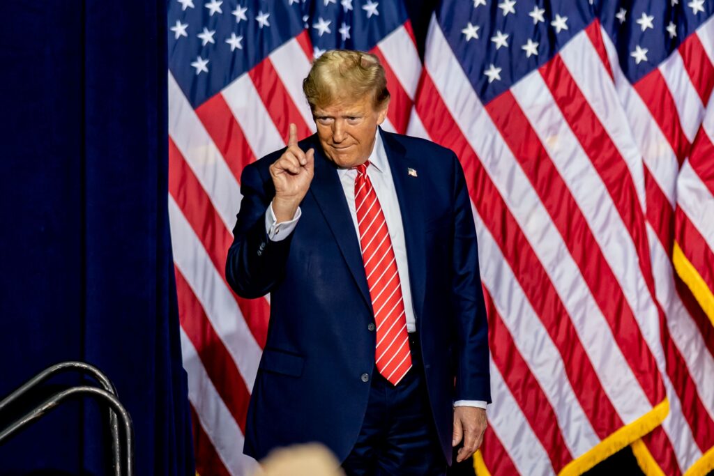 Trump Zölle Inflation USA: US-Flagge mit steigenden Preisdiagrammen und Handelszoll-Symbolen