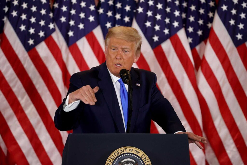 Trump Zölle auf Stahlimporte: Donald Trump bei einer Rede mit einem Stahlwerk im Hintergrund